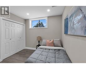 A bedroom with a large bed and a painting on the wall.