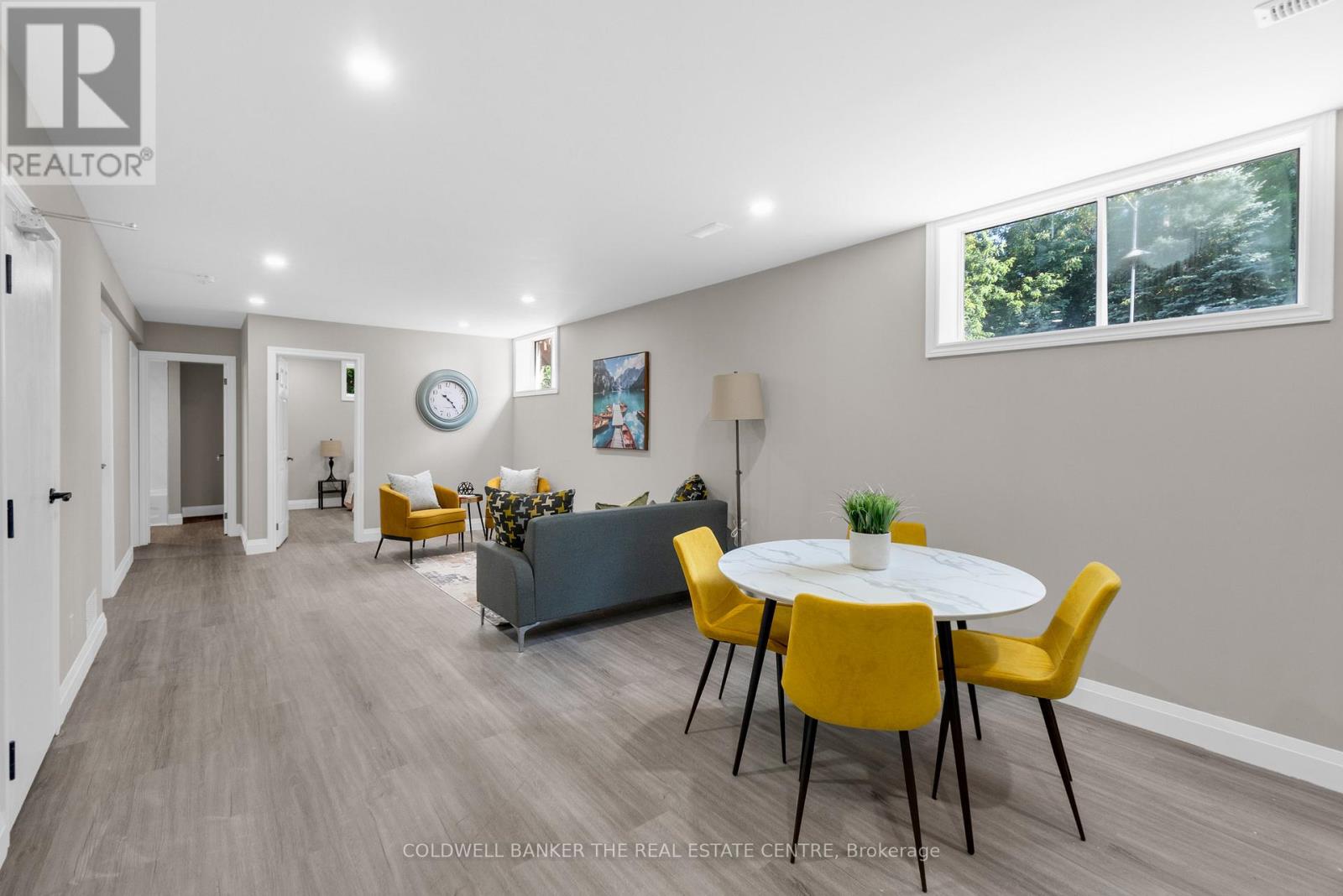 A dining room with a white table and yellow chairs.