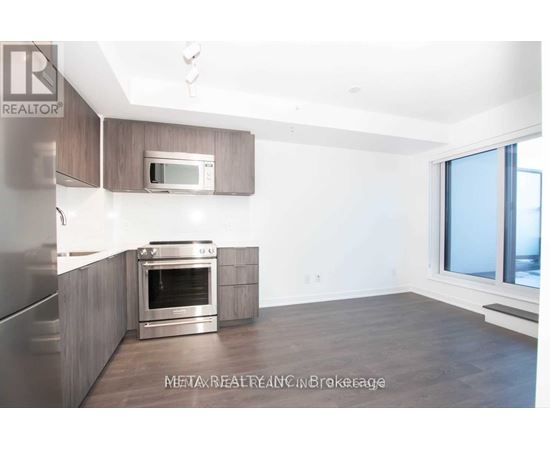 A modern kitchen with a stainless steel refrigerator, oven, and microwave.