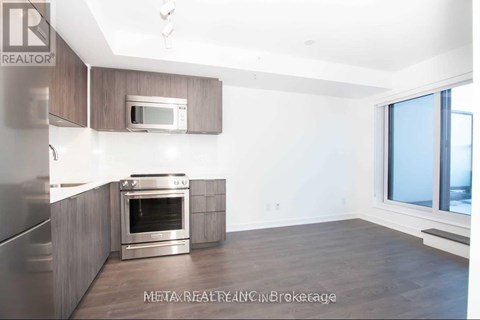 A modern kitchen with a stainless steel refrigerator, oven, and microwave.