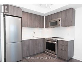 A modern kitchen with a refrigerator, oven, microwave, and sink.