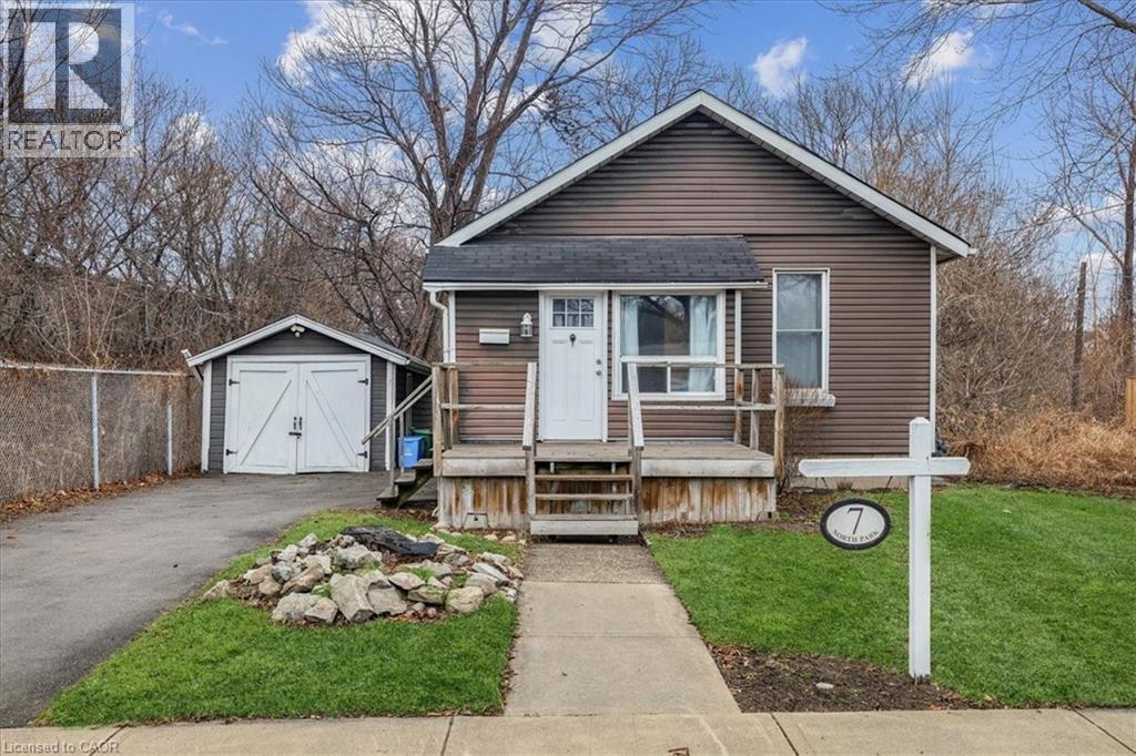 A house with a garage and a small shed is for sale.