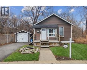 A house with a garage and a small shed is for sale.