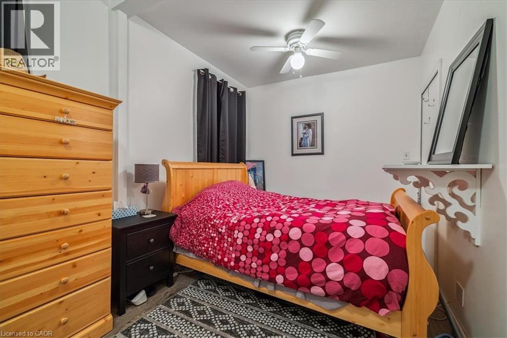A bedroom with a bed covered in a red and black bedspread.