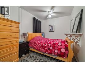 A bedroom with a bed covered in a red and black bedspread.