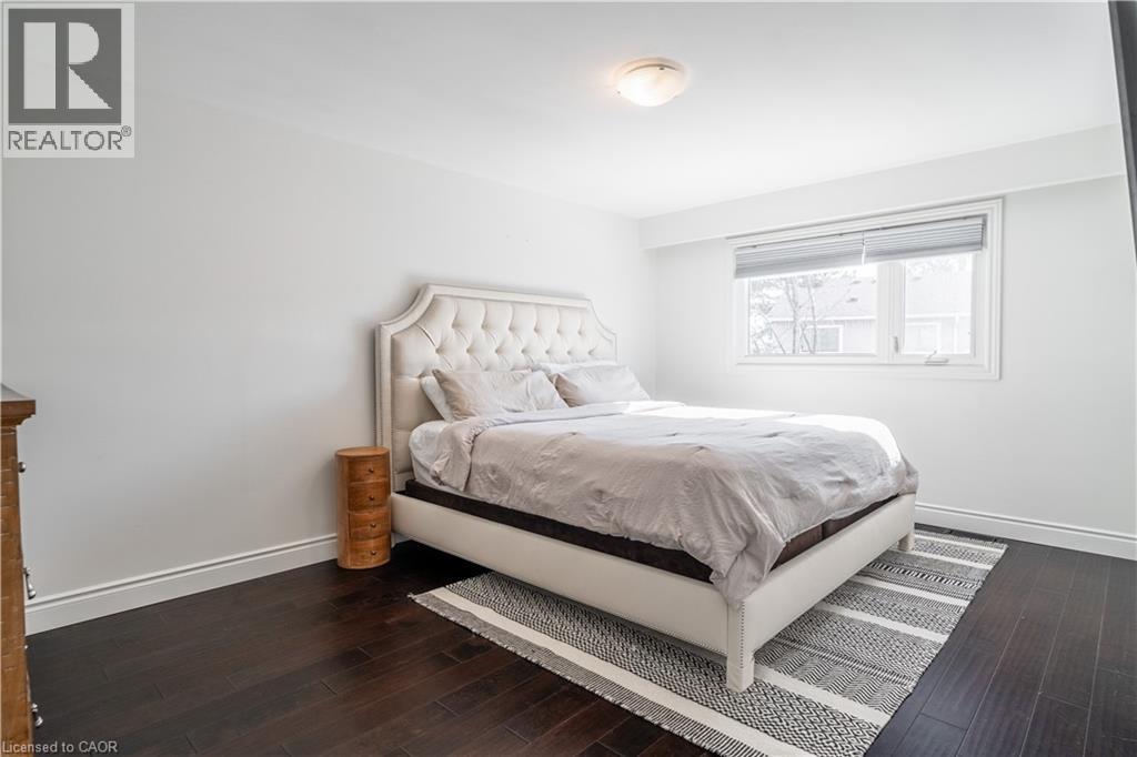 A bedroom with a large bed and a wooden floor.