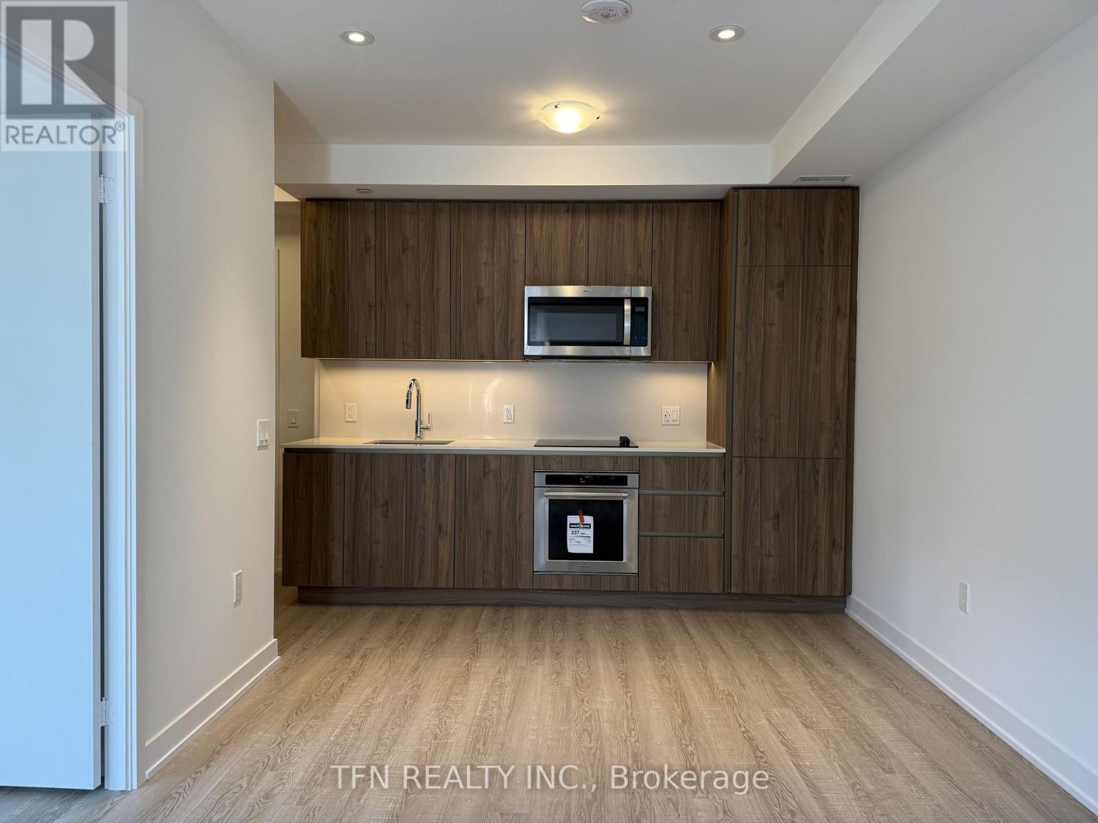 A modern kitchen with wooden cabinets and a microwave above the stove.