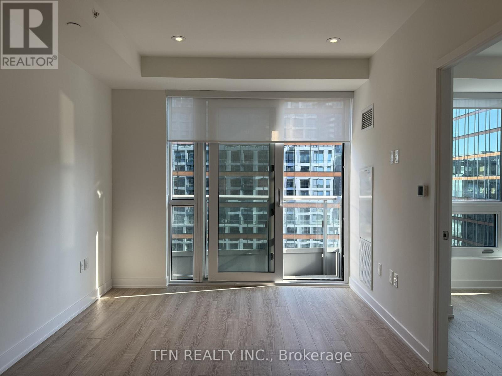 A room with a view of a cityscape through a glass door.