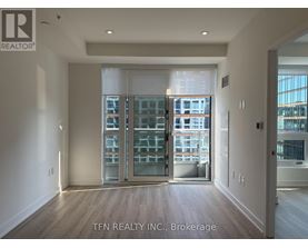 A room with a view of a cityscape through a glass door.