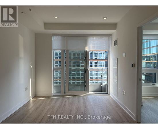 A room with a view of a cityscape through a glass door.