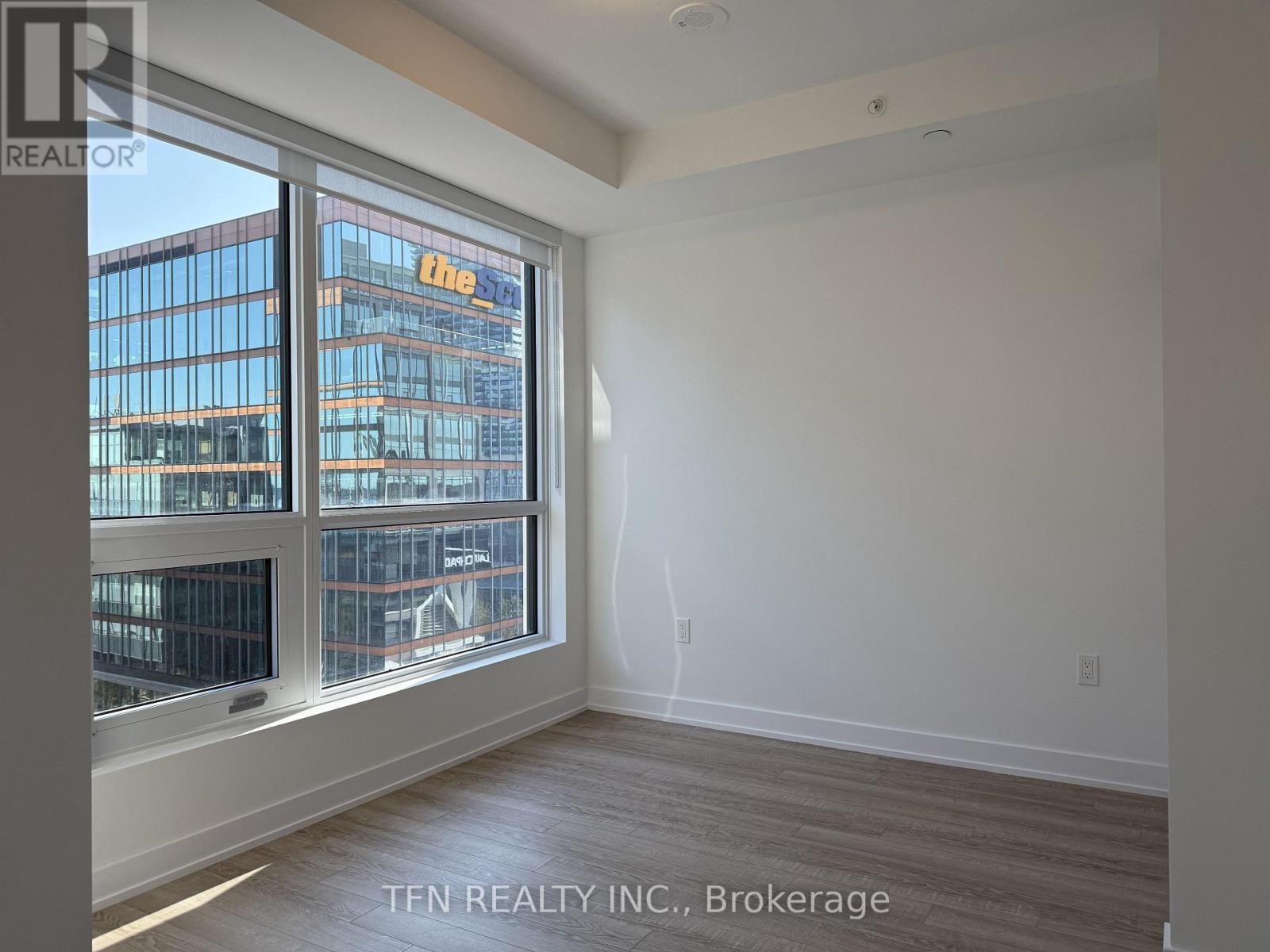 A room with a large window overlooking a cityscape.