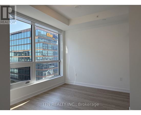 A room with a large window overlooking a cityscape.