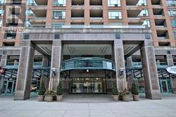 A large building with a glass entrance and a stone archway.
