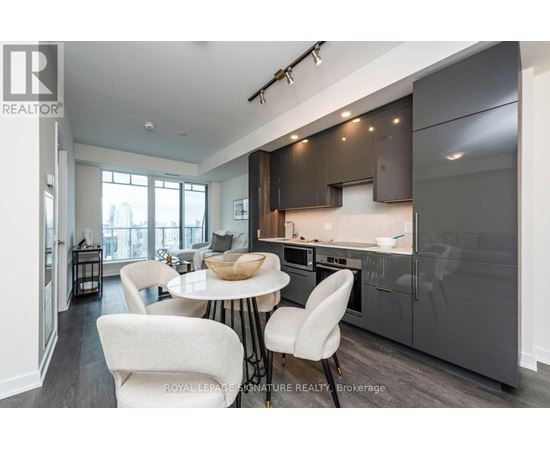 A modern kitchen with a dining table and chairs.