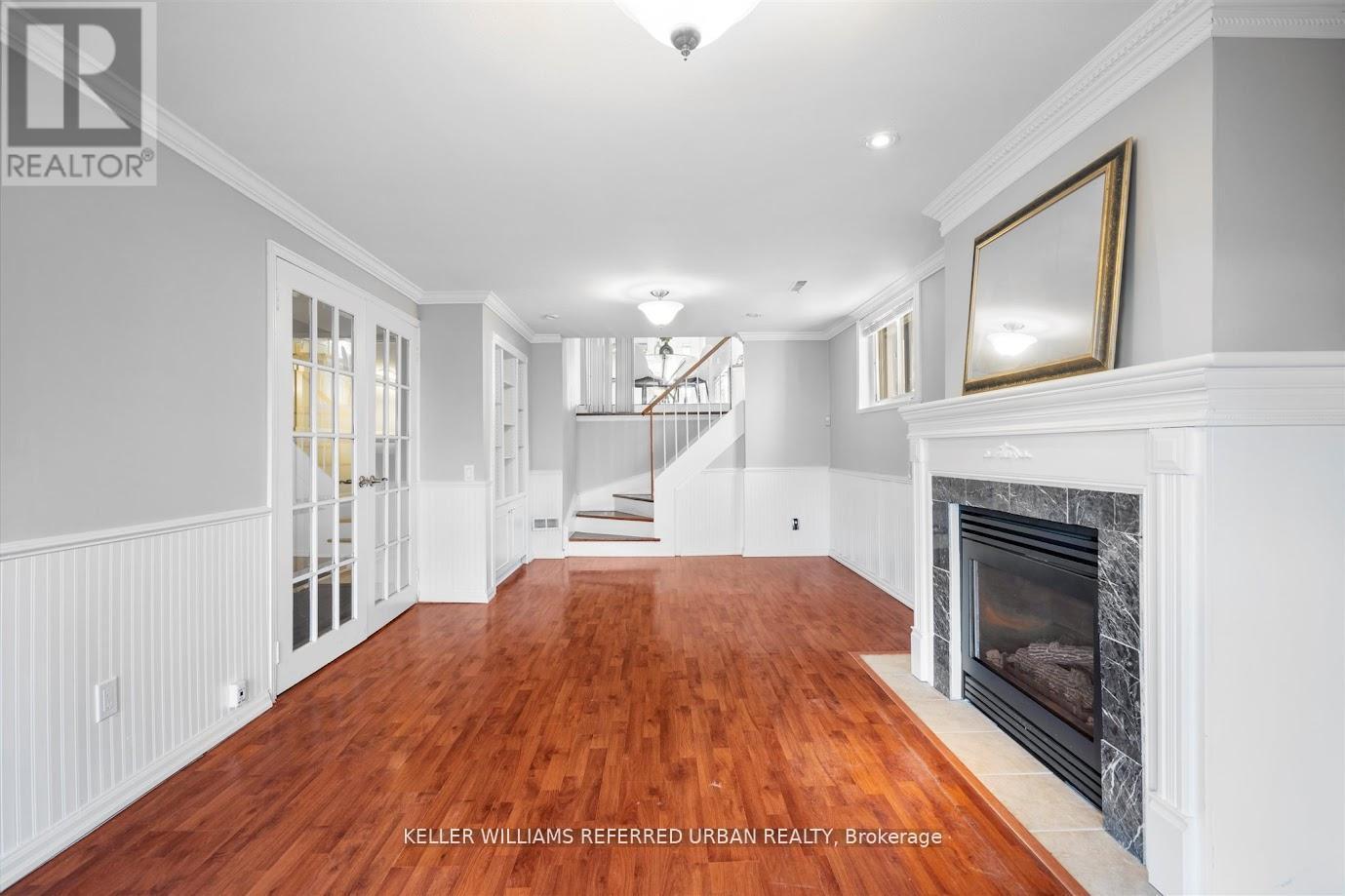 A spacious living room with wood flooring and a fireplace.
