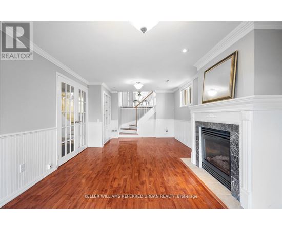 A spacious living room with wood flooring and a fireplace.