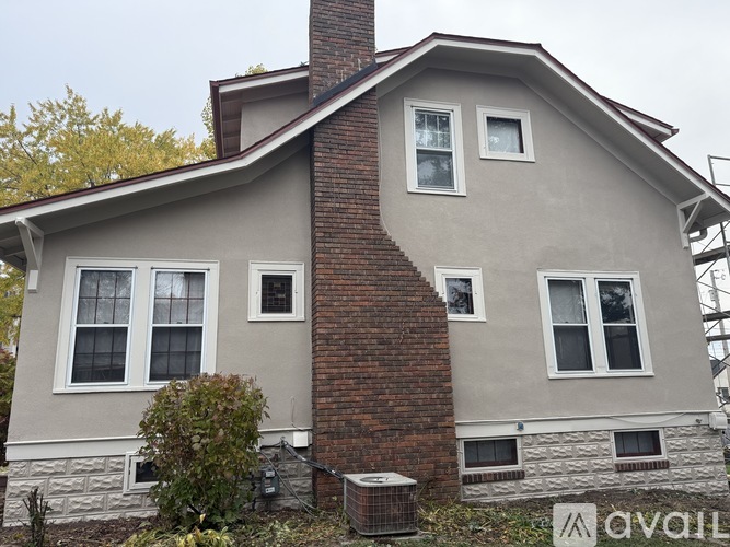 A house with a grey exterior and a brick chimney.