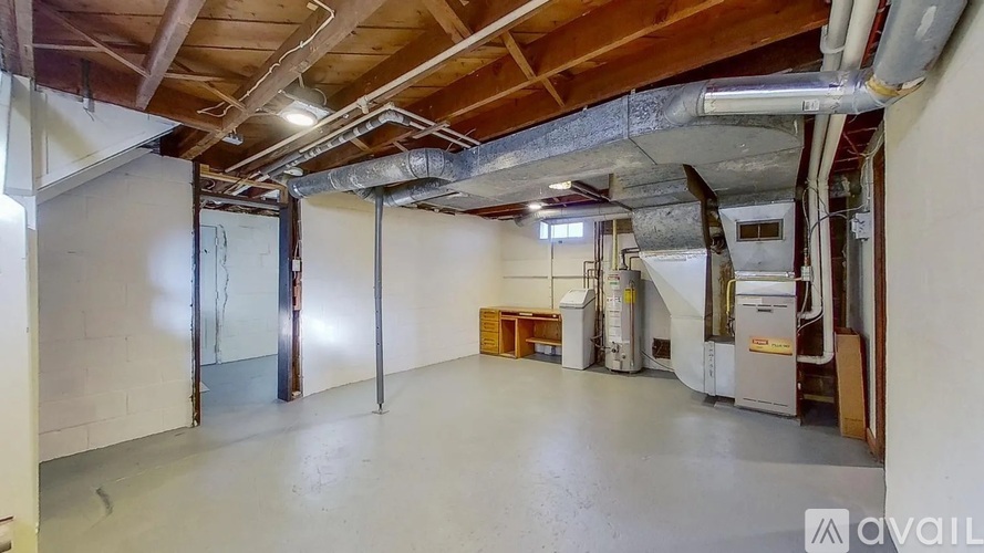 A spacious room with a high ceiling and exposed ductwork.