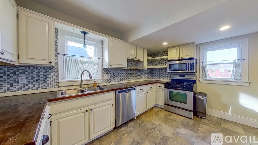 A kitchen with white cabinets and a tiled backsplash.