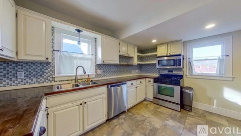 A kitchen with white cabinets and a tiled backsplash.