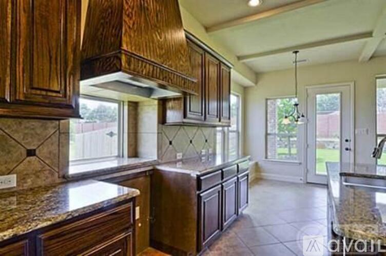 A kitchen with wooden cabinets and a granite countertop.
