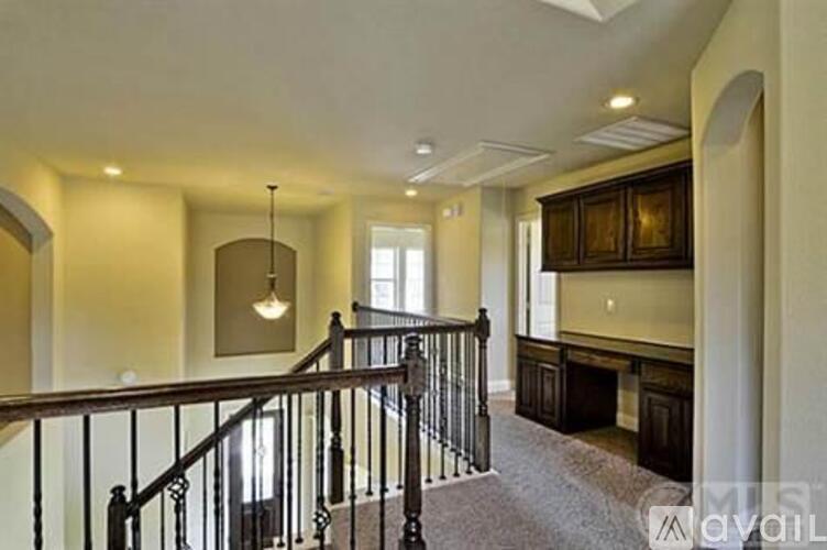 A staircase with a metal railing leads to a second floor.