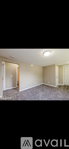 A room with a carpeted floor and a door leading to another room.