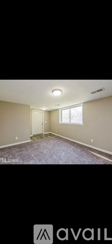 A room with a carpeted floor and a window.