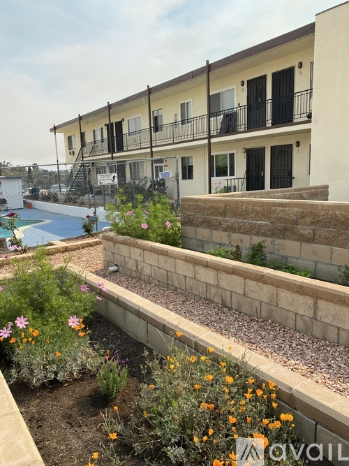 A building with a pool and a flower garden in front.