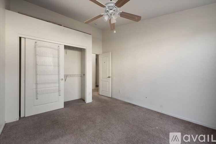 A room with a ceiling fan and two doors.