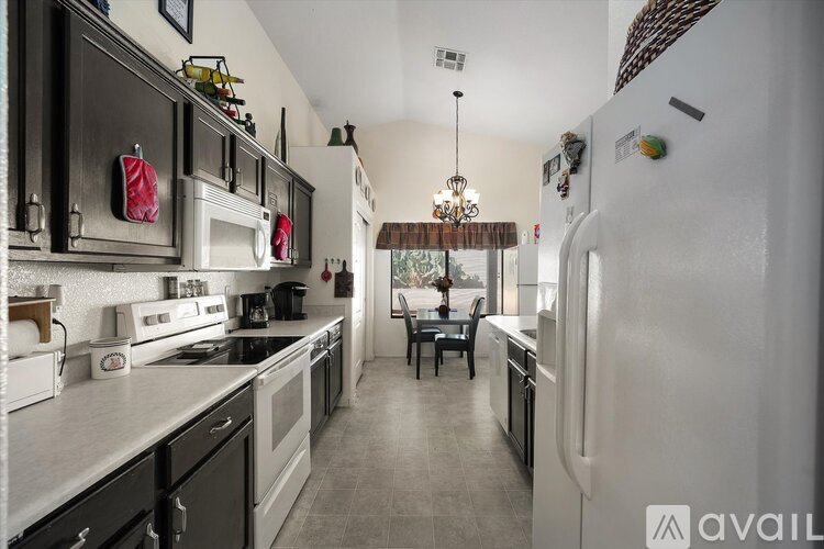 A kitchen with a black and white color scheme and a dining area.