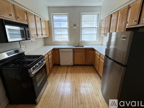 A kitchen with black appliances and wooden cabinets.