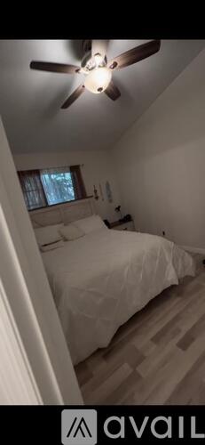 A bedroom with a bed and a ceiling fan.