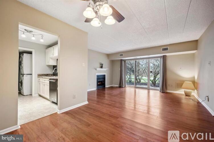 A spacious living room with hardwood floors and a ceiling fan.