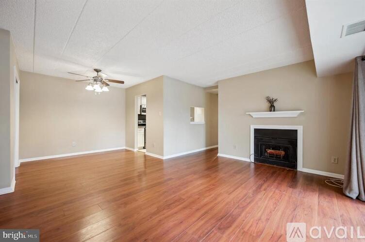 A living room with a fireplace and a ceiling fan.