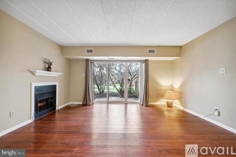 A spacious room with a fireplace and wooden flooring.