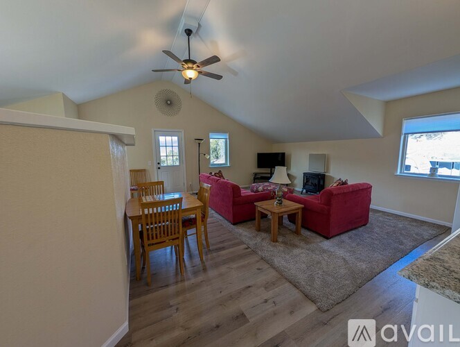 A living room with a red couch and a wooden table.