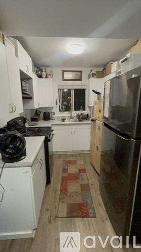 A kitchen with white cabinets and a black stove top.