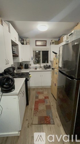 A kitchen with white cabinets and a black stove top.