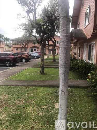 A tree in a grassy area in front of a building.