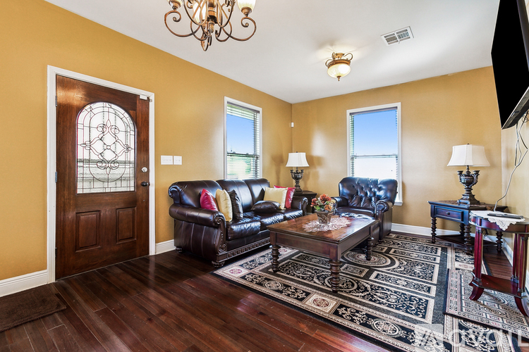 A living room with a brown leather couch and a wooden coffee table.