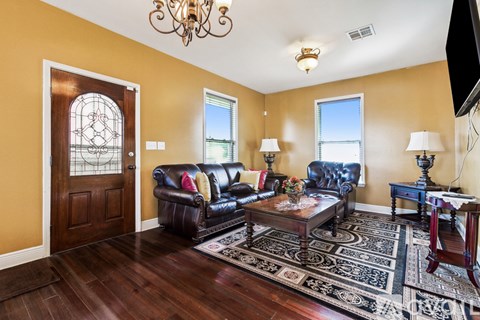 A living room with a brown leather couch and a wooden coffee table.