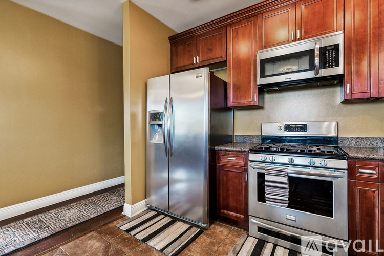 A kitchen with a stainless steel refrigerator, oven, and microwave.