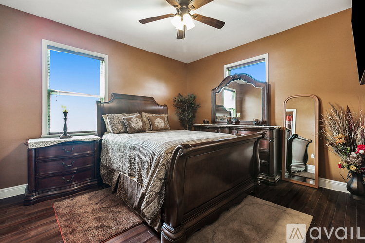 A bedroom with a large bed and a window with a view of a building outside.