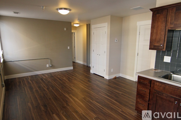 A kitchen with wooden floors and cabinets.