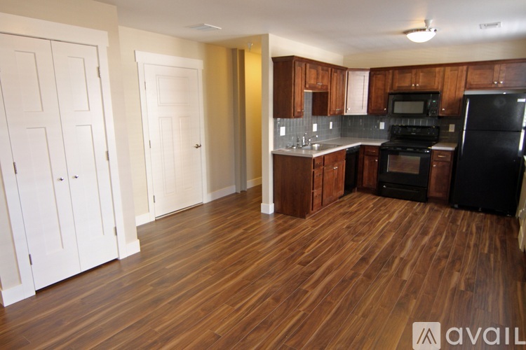 A room with wooden floors and a window with blinds.
