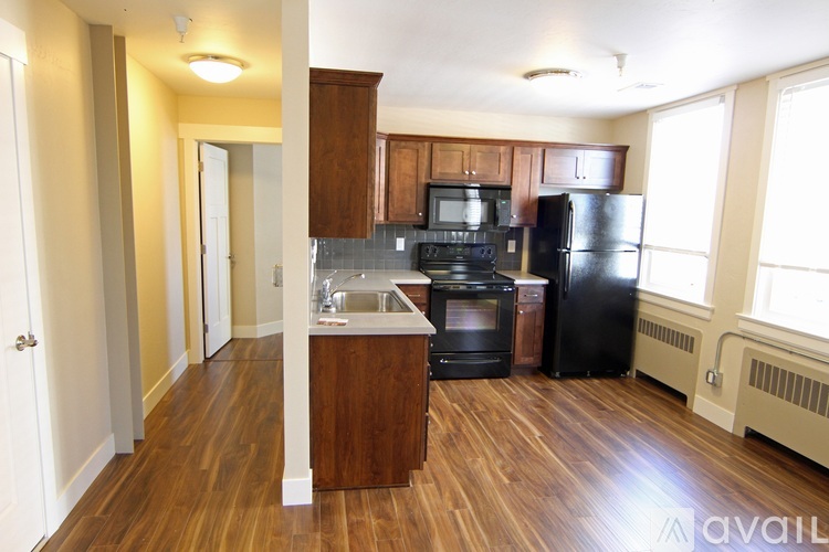 A kitchen with black appliances and wooden cabinets.