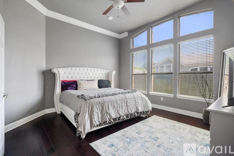 A bedroom with a large bed and a ceiling fan.