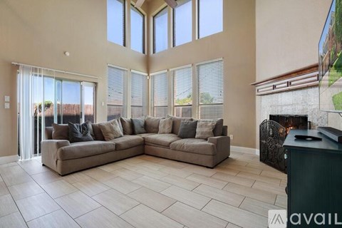 A living room with a large sectional sofa and a fireplace.