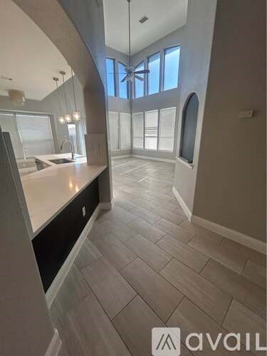 A spacious bathroom with a large mirror and a window.